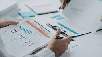 Group of confident business people point to graphs and charts to analyze market data, balance sheet, account, net profit to plan new sales strategies to increase production capacity. video