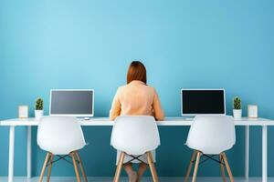 Woman working at a desk with computers. Internet and computer use concept. photo