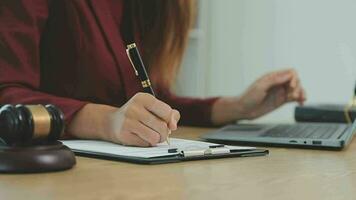 zaken en advocaten bespreken contractpapieren met koperen schaal op bureau in kantoor. wet, juridische diensten, advies, rechtvaardigheid en wet concept foto met film grain effect video