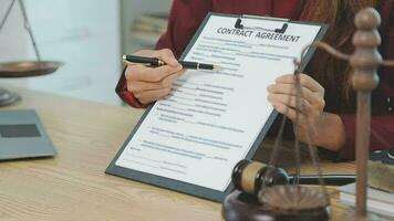 zaken en advocaten bespreken contractpapieren met koperen schaal op bureau in kantoor. wet, juridische diensten, advies, rechtvaardigheid en wet concept foto met film grain effect video