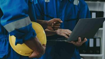 drie zwaar industrie ingenieurs staan in pijp fabricage fabriek, gebruik digitaal tablet computer, hebben discussie. groot pijp geassembleerd. ontwerp en bouw van olie, gas- en brandstoffen vervoer pijpleiding video