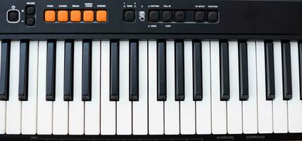 de cerca de piano llaves. piano negro y blanco llaves y piano teclado musical instrumento metido a el hogar balcón durante soleado día. foto