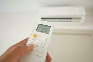 Close up of man hand holding air condition remote. photo