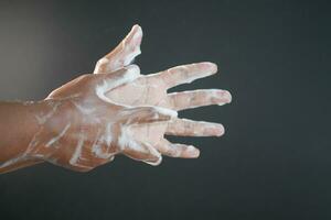 young man washing hands with soap warm water photo