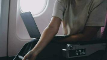 Woman using laptop while is sitting in plane near window. video