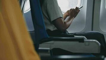 in viaggio e tecnologia. volante a primo classe. bella giovane imprenditori donna utilizzando smartphone mentre seduta nel aereo. video