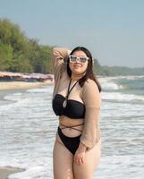 retrato joven mujer asiático gordito grasa linda hermosa uno persona en bikini negro sexy vista frontal tropical mar playa blanco arena limpiar y azul cielo antecedentes calma naturaleza Oceano ola agua viaje divertido contento foto