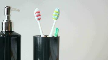 bathroom soap dispenser and toothbrush cup. video