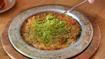kunafa with a wipe cream on a plate . video