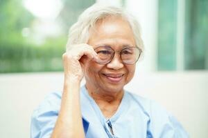 Asian senior woman wearing eyeglasses or vision glasses at home care service. photo