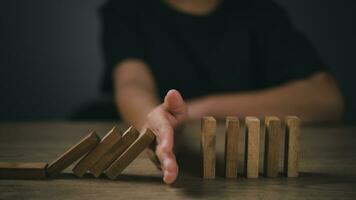 Hand-stopping domino effect. Concept of risk protection, business solution, or successful intervention strategy. photo