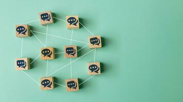 Concept of online communication or social networking. Wooden cubes with speech bubbles linked to each other with lines. photo