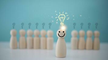 Wooden doll with a light bulb instead of a head standing in front of a crowd of people. idea creative intelligence thinking concept. photo