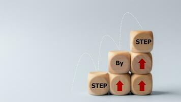 Business concept image with wooden cubes word step by step on wooden cubes. Achievement or progress in business career. photo