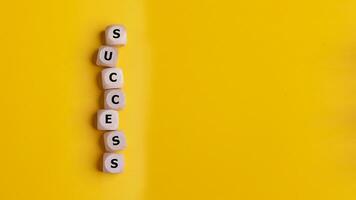 Cubes with the word success on a yellow background, success business concept. photo