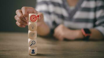 bloque de madera de mano con objetivo comercial, estrategia, objetivo, misión, acción, objetivo, trabajo en equipo y concepto de idea foto