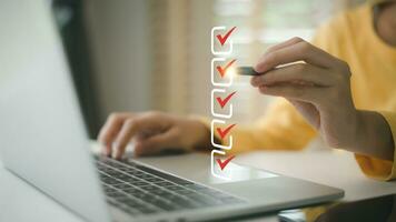 Women use pens to tick the correct sign mark in the checkbox for the quality document control checklist and business approves project concept. photo