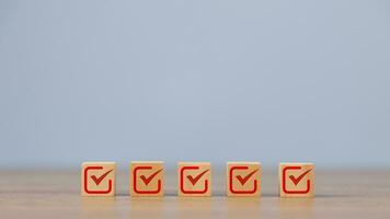 Checklist, Check mark icons for the jobs list on the wooden blocks. Task lists, Surveys, Assessments, Lists, Confirm items, Quality Control goals achievement of business success. photo