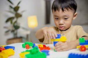 The kid playing with colorful toy blocks. Little boy building the car of block toys. Educational and creative toys and games for young children. photo