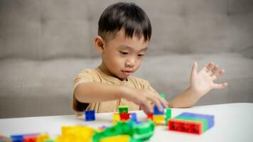 The kid playing with colorful toy blocks. Little boy building the car of block toys. Educational and creative toys and games for young children. photo