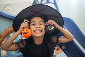 Happy Asian child girl in a witch costume to Halloween. trick or treat. Kids trick or treating. photo