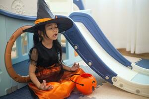 Happy Asian child girl in a witch costume to Halloween. trick or treat. Kids trick or treating. photo