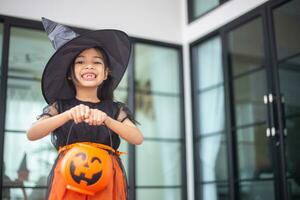 Happy Asian child girl in a witch costume to Halloween. trick or treat. Kids trick or treating. photo