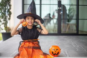 Happy Asian child girl in a witch costume to Halloween. trick or treat. Kids trick or treating. photo