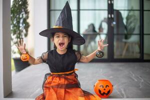 Happy Asian child girl in a witch costume to Halloween. trick or treat. Kids trick or treating. photo