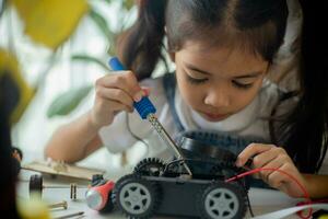 vástago educación concepto. asiático joven niña aprendizaje robot diseño. foto