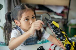 STEM education concept. Asian young girl learning robot design. photo