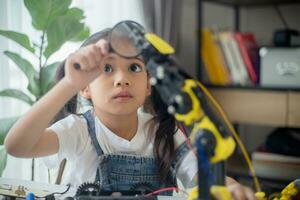 STEM education concept. Asian young girl learning robot design. photo