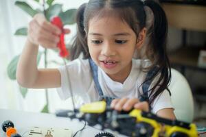 vástago educación concepto. asiático joven niña aprendizaje robot diseño. foto