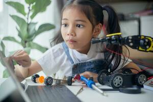 STEM education concept. Asian young girl learning robot design. photo