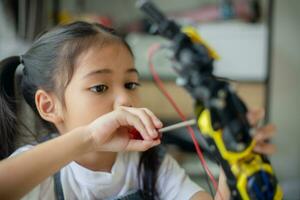 STEM education concept. Asian young girl learning robot design. photo