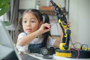 STEM education concept. Asian young girl learning robot design. photo