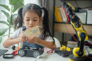 STEM education concept. Asian young girl learning robot design. photo