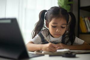 Young Asian Cute girl studying with laptop at home. Online learning concept. photo