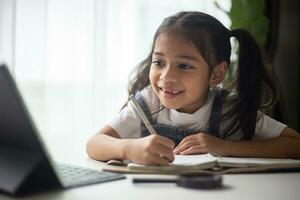 Young Asian Cute girl studying with laptop at home. Online learning concept. photo