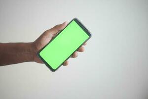 Close up of young man hand using smart phone with green screen photo