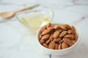 aceites de almendras y nueces frescas en la mesa foto