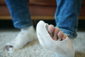 men feet with dirty socks while sitting on sofa photo