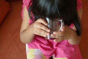 child hand holding a glass of water photo