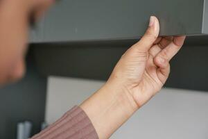 women hand open a kitchen cabinet drawer photo