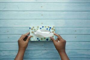 hand pull out a piece of tissue from tissue paper box photo