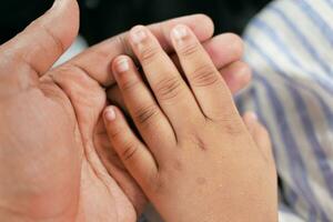 father holding hand of baby child, close up . photo