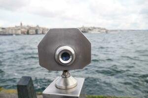 Coin-operated binoculars looking out over city , photo