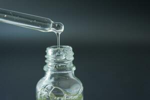 essential oil in dropping from a pipette in a container photo