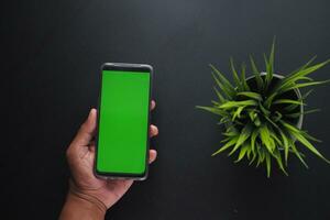 top view of young man hand using smart phone with green screen photo