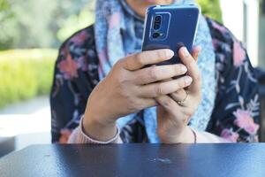 Cerca de la mano de la mujer sosteniendo un teléfono inteligente. foto